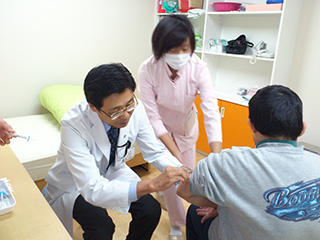 済生会三条病院では障害者施設に赴いて健診を行っている。写真は予防接種をする郷秀人院長