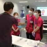 新人看護師研修で新人看護師が先輩看護師から指導を受けながら、楽しく活動している写真