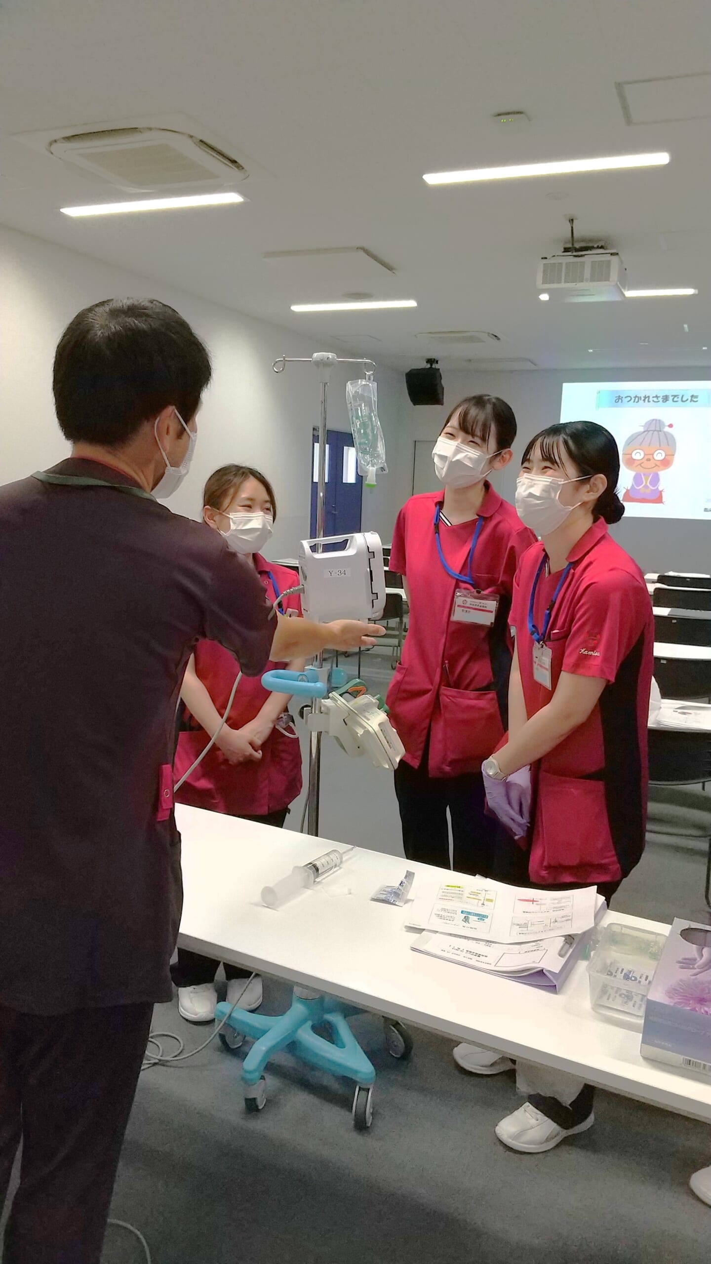 新人看護師研修で新人看護師が先輩看護師から指導を受けながら、楽しく活動している写真