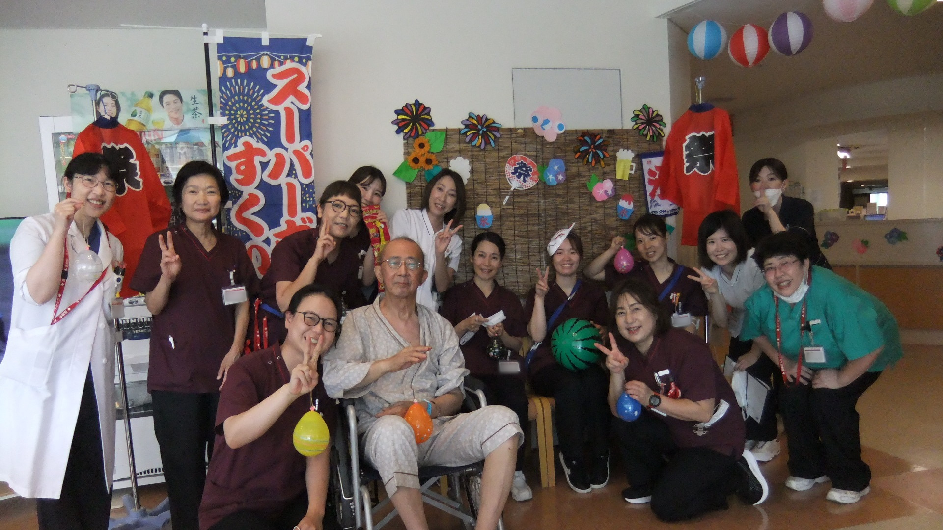 患者さん、そのご家族、職員が、お面をかぶったり、ヨーヨーをしたりしている集合写真