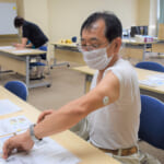 「リブレ」を腕の皮膚に貼り、血糖値を測定している福井県済生会病院の職員の写真
