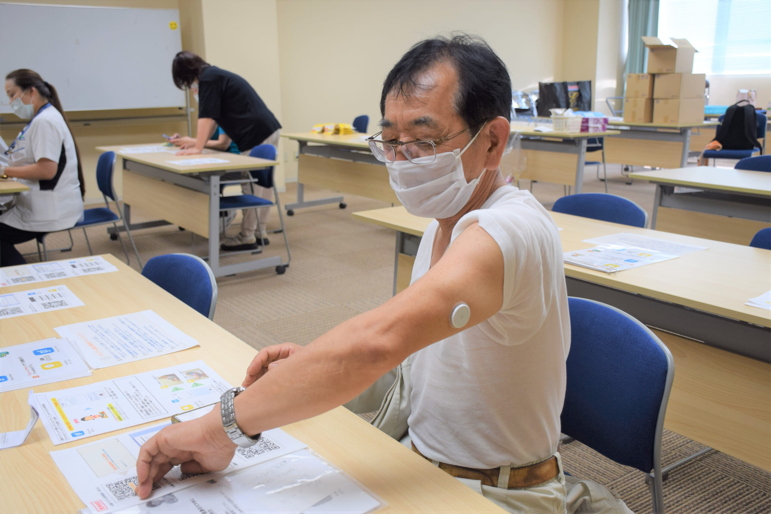 「リブレ」を腕の皮膚に貼り、血糖値を測定している福井県済生会病院の職員の写真