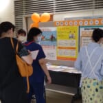 来院者が認知症に係るポスター展示を読んだり、リーフレットを職員から受け取っている写真