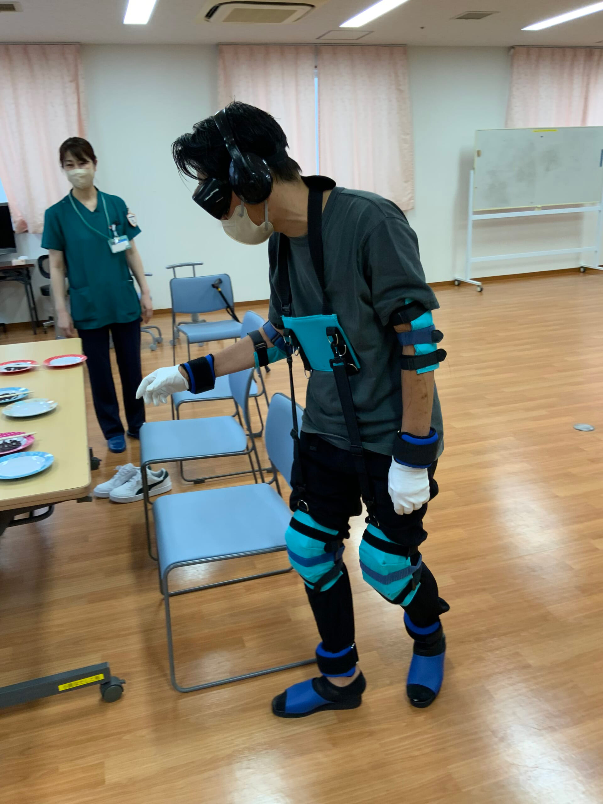 要介護高齢者の疑似体験で専用の装具により身体の動きや見え方、聞こえ方に制限を加えることで、思うように動けない、見えない、聞こえないなどの不自由さを体感している写真