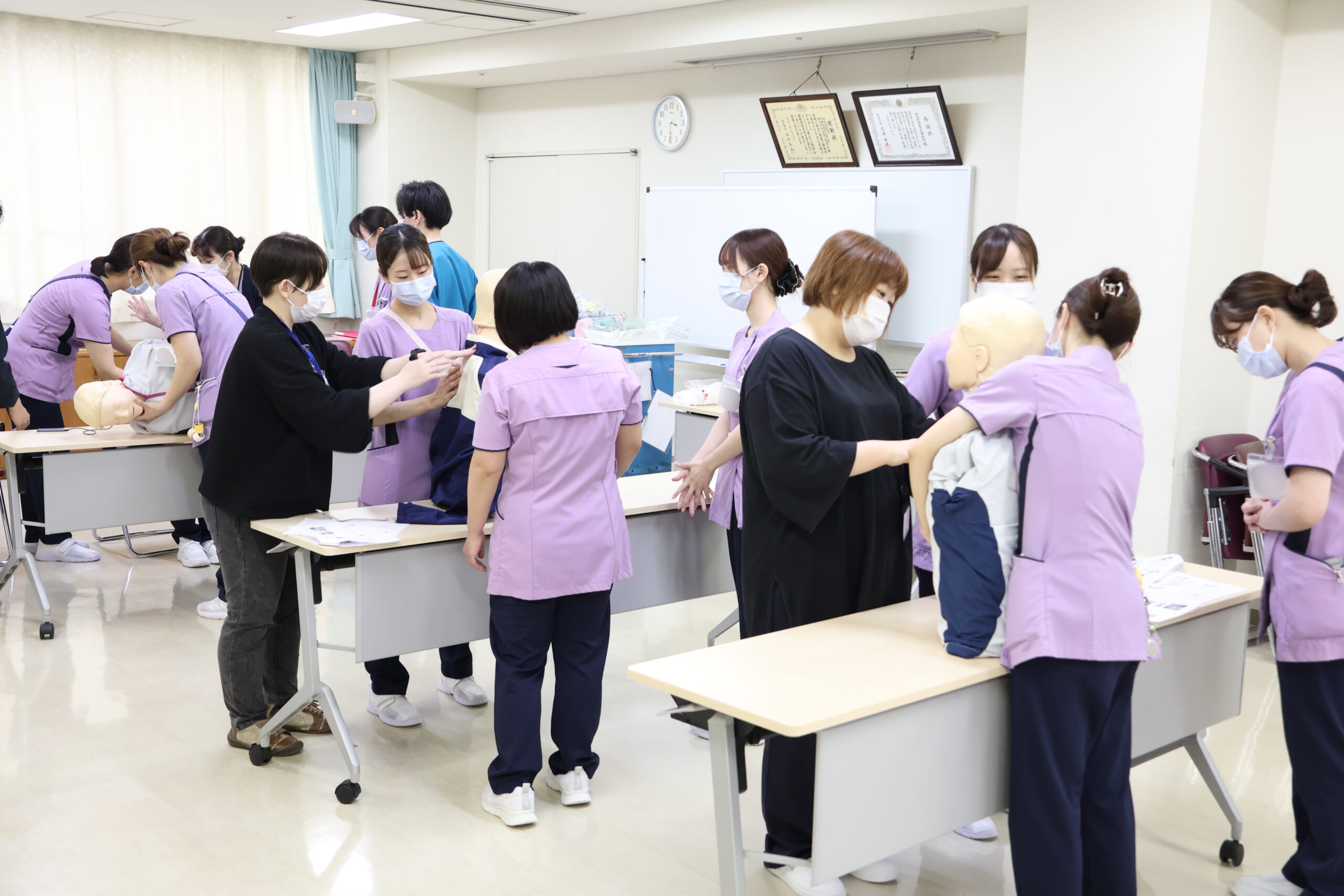 窒息時の対応や気管内挿管の介助を模型を用いて体験している写真