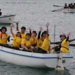 船の上で、参加したメンバーが笑顔でピースをしている写真