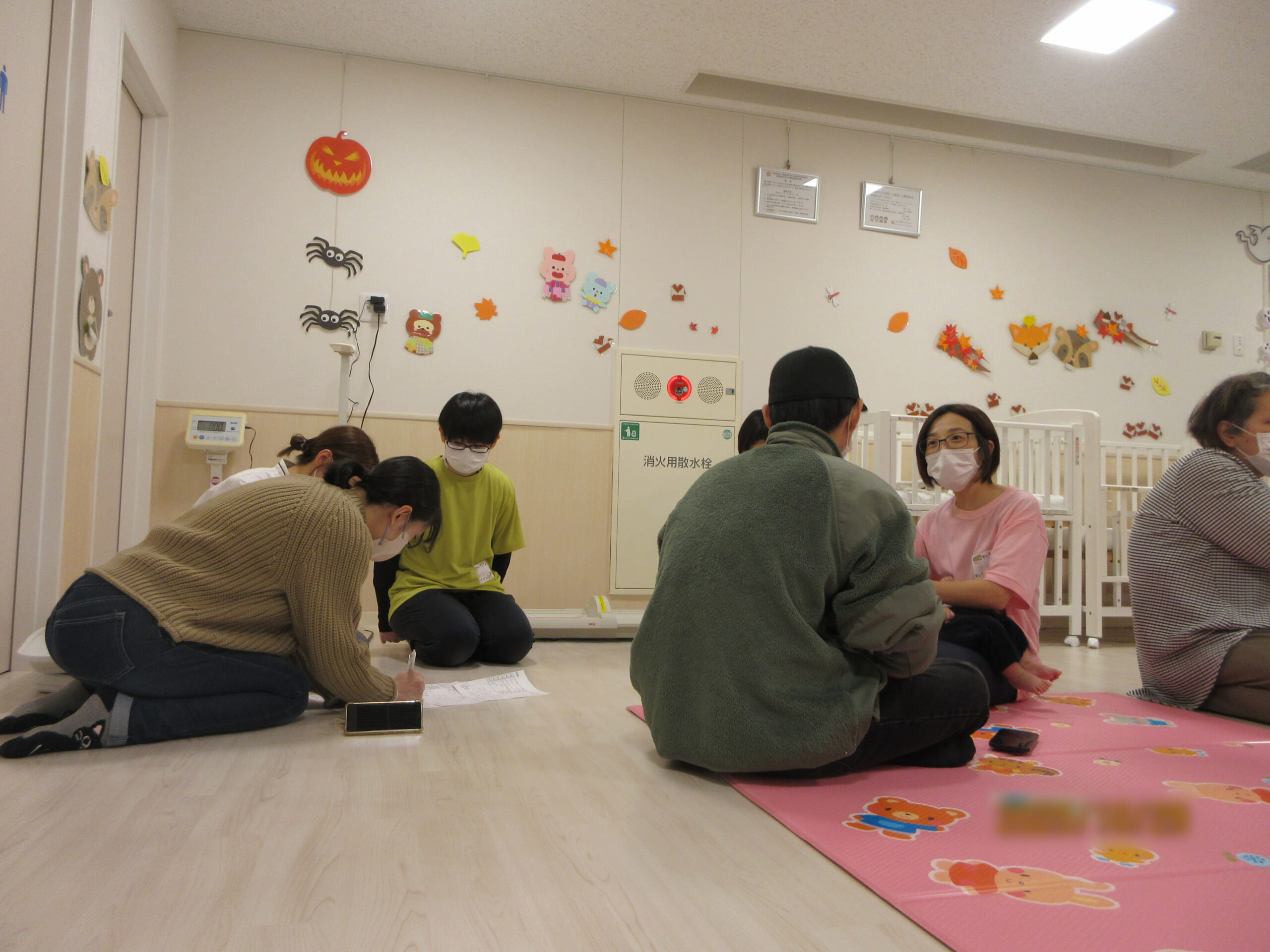 中央病院付属乳児の職員が参加者に乳児院の役割を説明したり、子育てについて相談を聞いている写真