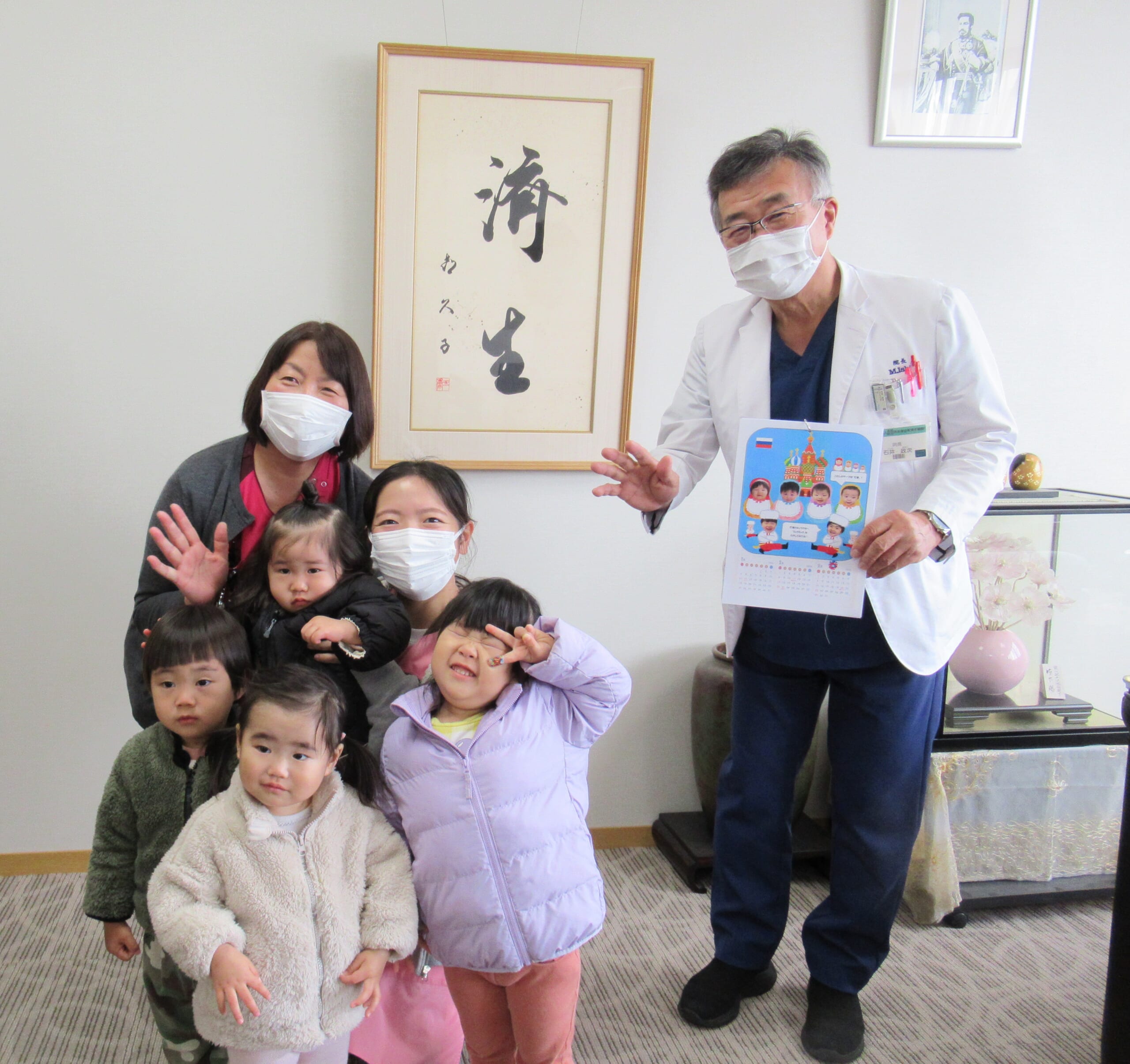 石井政次院長と阿部富貴子看護部長と子どもたちの集合写真