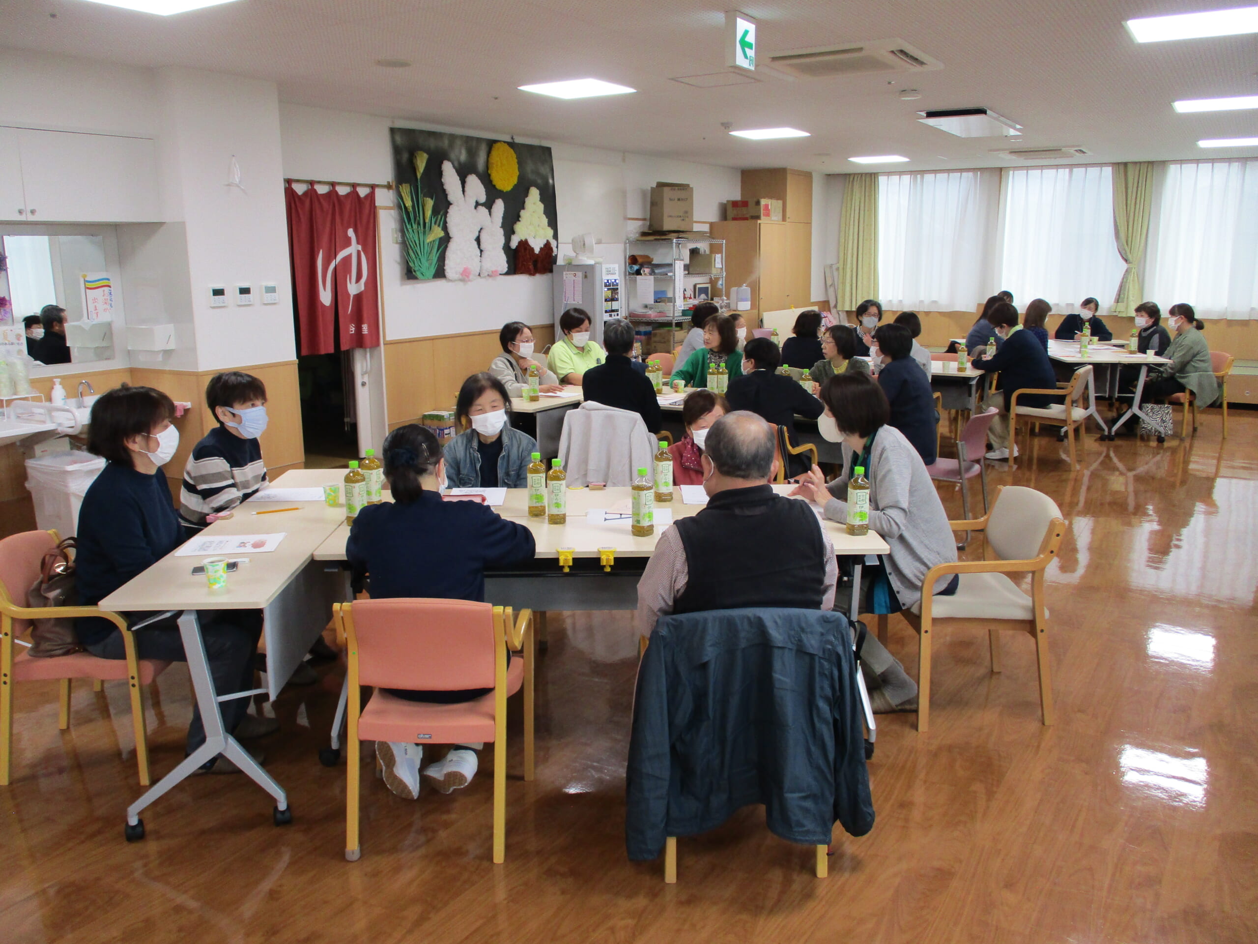 利用者ご家族が8人くらいのグループになって、悩みを打ち明け合っている写真