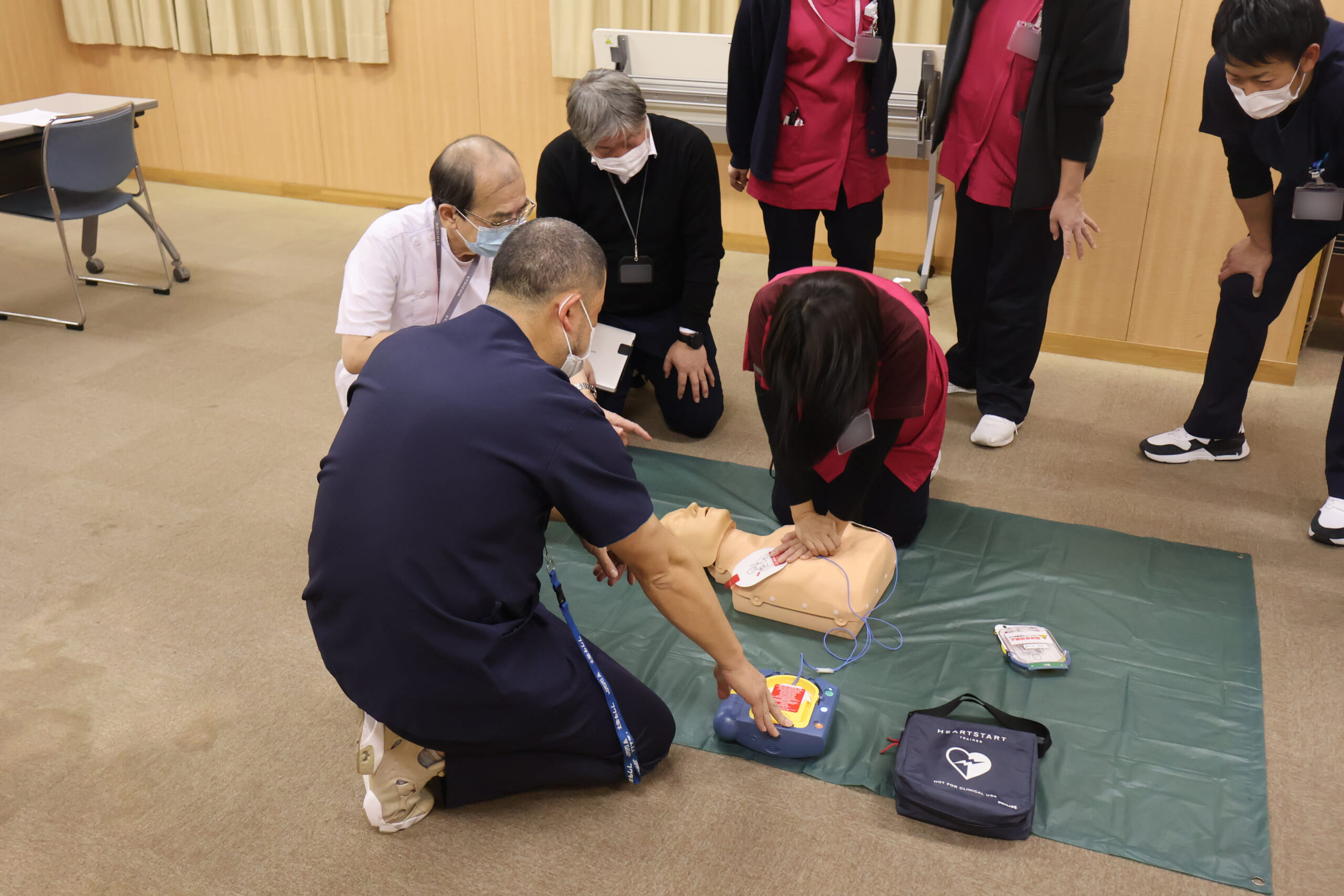 AEDを用いて一次救命処置を学んでいる写真