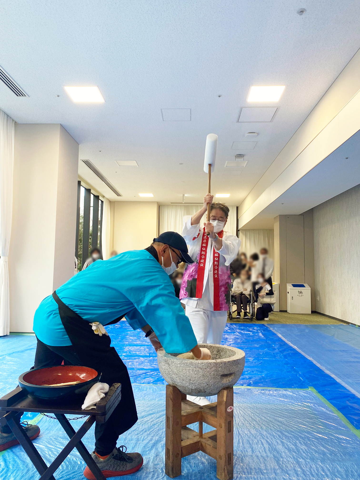 杵と臼を用いて、餅つきをしている写真