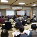 参加者が講義内容についてマイクを持って質問している写真